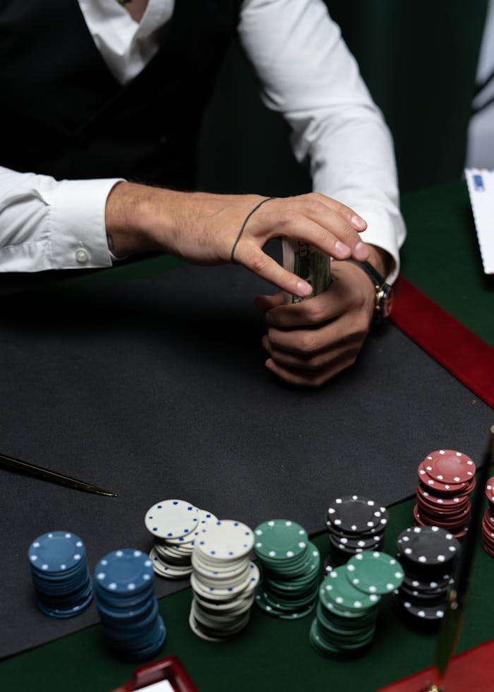 digital-01 Close-up of a person handling money and poker chips at a casino table.